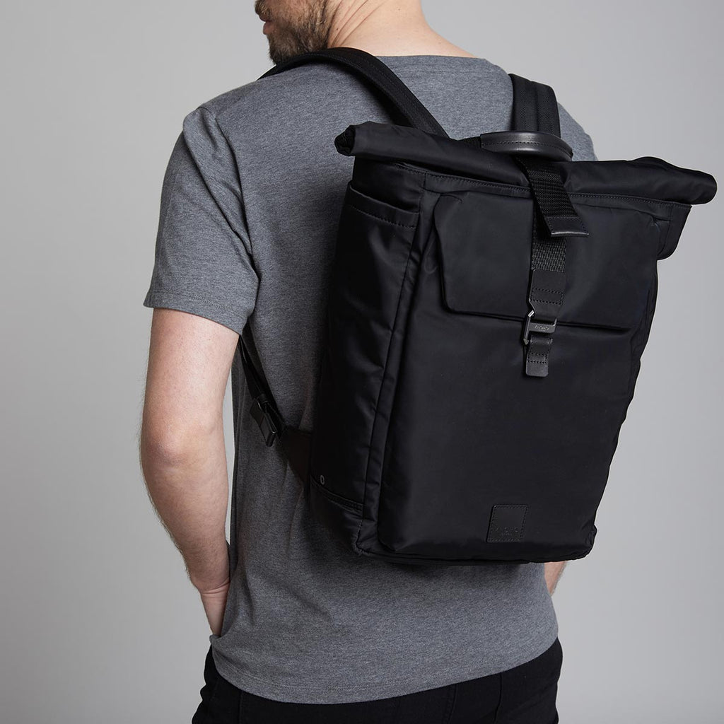 KNOMO Novello Roll-Top Laptop Backpack Male Model Wearing 15" -  Black | knomo.com